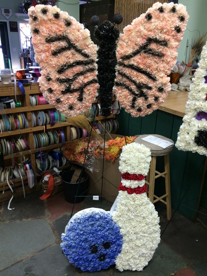 flower arrangements made to look like a butterfly and bowling ball and pin